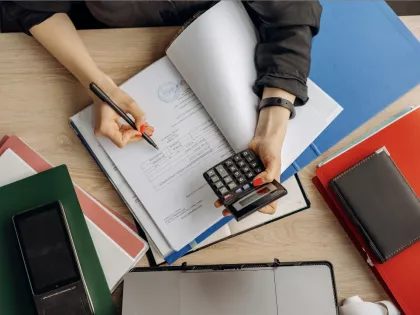 table-feuilles-mains-avec-stylo-et-calculatrice-IHECF-Lyon